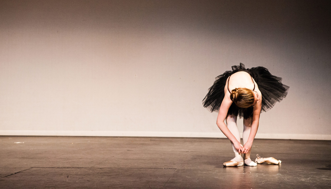 A ballet dancer bowing during rehersals