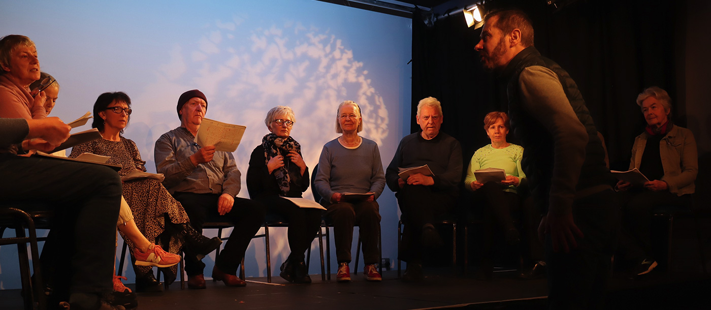 Our Neighbourhood group sitting on stage for rehearsals at dlr Mill Theatre